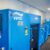 Four bright blue Venti compressors in a sales showroom.