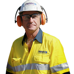 A man wearing yellow and blue NPS high-visibility work wear, safety hat, glasses and ear protection looks at the camera.